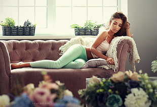 woman wearing teal pants sitting on couch