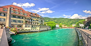 white and brown concrete building and body of water, Switzerland, hotel, river, hills