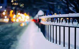 black steel railing with snow in shallow photography