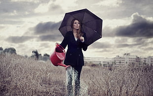 photo of woman walking on field holding umbrella and watering can HD wallpaper