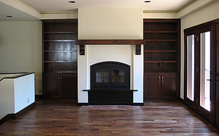 brown and white fireplace beside brown wooden cabinet