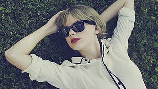 Taylor Swift lying on green grass lawn HD wallpaper