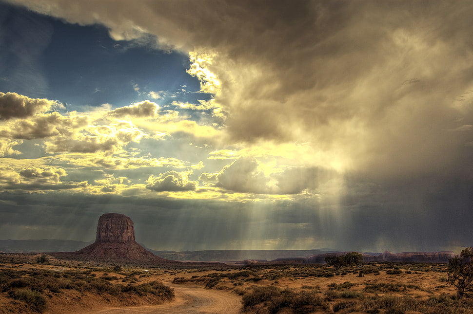 brown mountain under white cloudy sky with sun light HD wallpaper