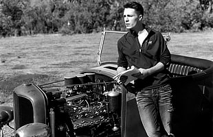 grayscale photo of a man wearing dress shirt on a vintage car