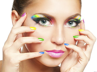 close up photo of woman with multicolored nail polish and eyelashes