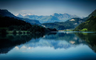 body of water and mountain alps at distance