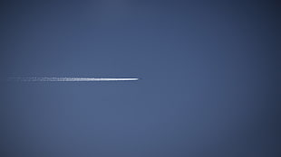 photography of a jetplane with contrail