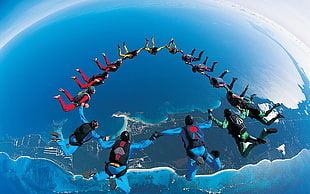 group of people skydiving forming a circle during daytime