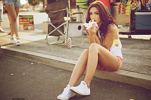 woman wearing white tank top and pink denim short shorts sitting beside road HD wallpaper