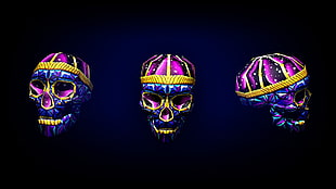 three purple and pink human skull decors