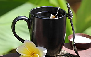 black ceramic mug with stainless steel teaspoon