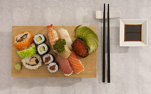 varieties of sushi beside black chopsticks
