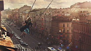 woman swinging above buildings digital wallpaper