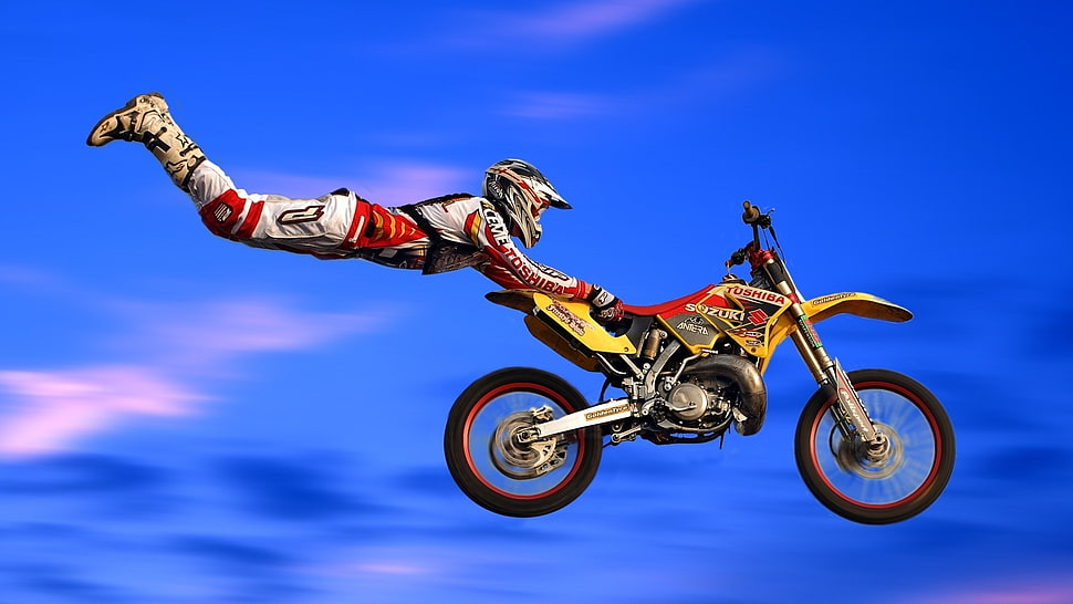 Man performing stunt with yellow and red motocross dirt bike HD wallpaper