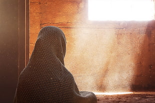 woman with grey scarf sitting facing the window