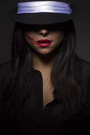 woman wearing black dress shirt with red lipstick and hat