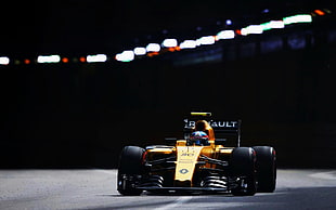 yellow F1 race car on road at nighttime