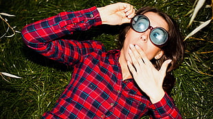 woman in sunglasses and western shirt lying on grass
