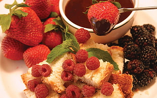 raspberry and strawbeery on white ceramic plate
