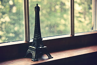 black metal Eiffel Tower scale model near window