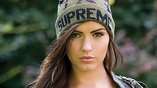 selective focus photo of woman wearing gray Supreme knit hat