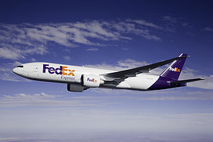 white and blue fedex airplane under blue and white cloudy sky during daytime