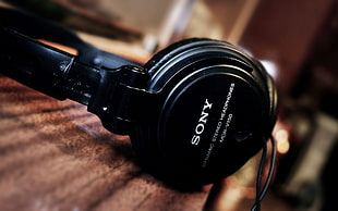 black Sony sterep headphones on table HD wallpaper