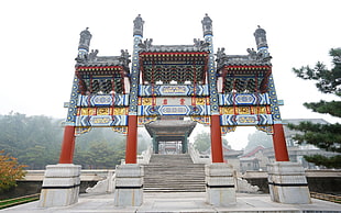 architectural photography of gray and red temple during foggy daytime