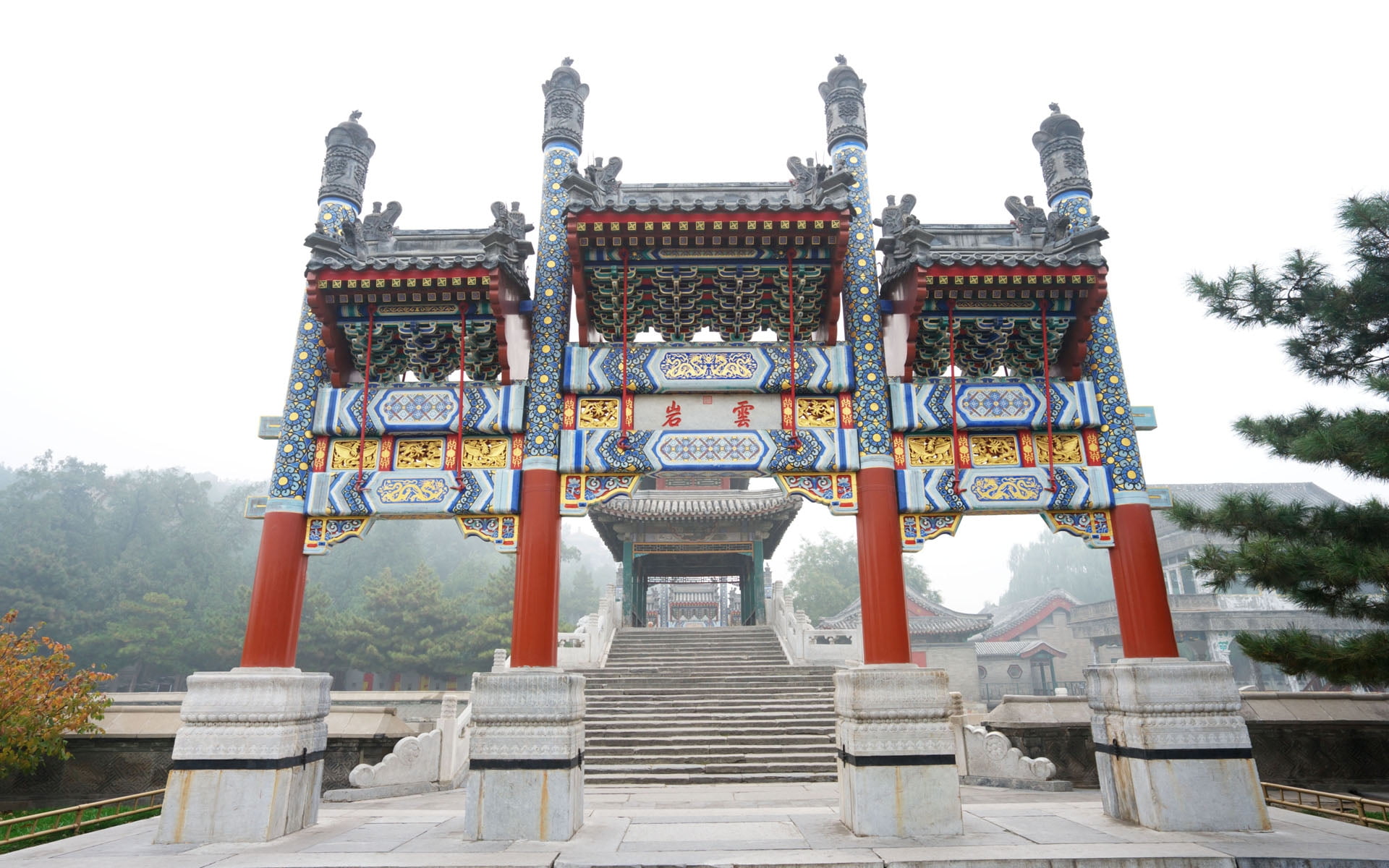 architectural photography of gray and red temple during foggy daytime