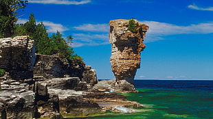 brown rock formation on the sea during daytime