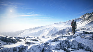 man standing on snow field mountain during daytime