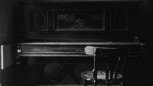 grayscale photography of upright piano with stool