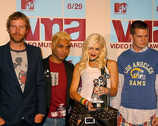 3 men and woman standing behind video music awards