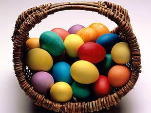 assorted color eggs with brown wicket basket