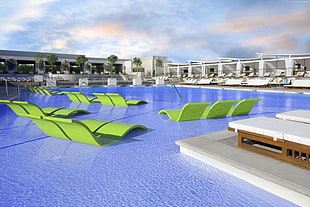 green outdoor lounges beside pool
