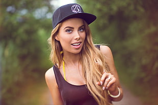 woman wearing brown tank top and black fitted cap