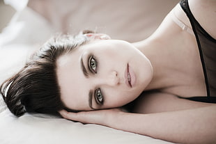 woman wearing black shirt lying on bed