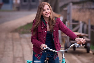 women's red jacket white driving a bicycle