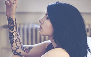 woman with arm tattoo smoking