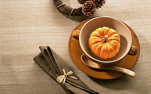pumpkin inside white and brown ceramic cup
