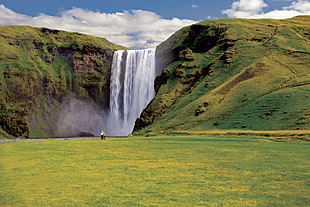 man standing in front of water falls during daytime