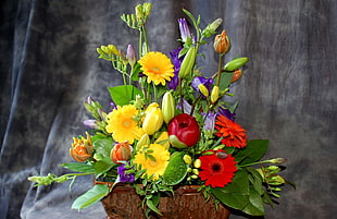 red, yellow, and purple flower arrangement in brown pot