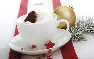 white ceramic mug filled with white cream and chocolate on top