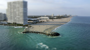 panoramic photo of gray sand beach near high-rise building