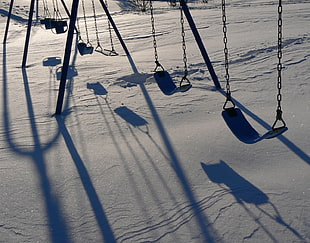 photo of black playground swing on snow