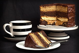 sliced of moist cake on white ceramic saucer with fork beside ceramic cup