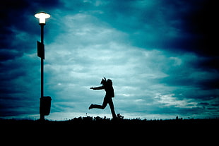 silhouette photography of a person jumping on a ground near outdoor post HD wallpaper