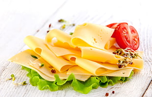sliced cheese and tomatoes above green vegetable