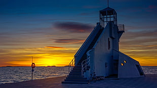 photo of stairway next to body of water during sunset, lighthouse, bicycle, sunset, water