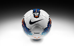 white, blue, and orange Nike soccer ball